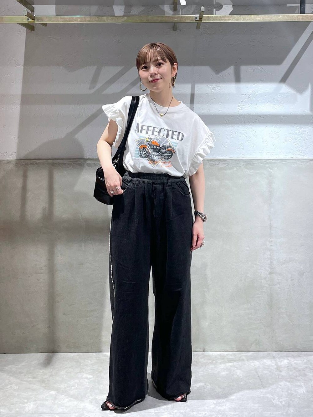 ホワイト系のTシャツ/カットソー、ブラック系のボストンバッグ、ブラック系のデニムパンツを着用したレディースの夏コーディネートの2枚目の写真