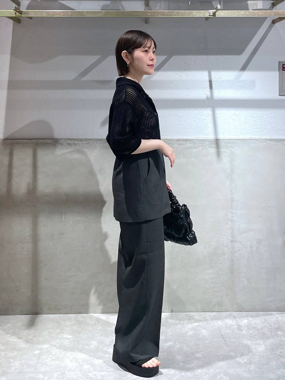 ブラック系のサンダル、ブラック系のショルダーバッグ、ブラック系のニット/セーターを着用したレディースの春コーディネートの3枚目の写真