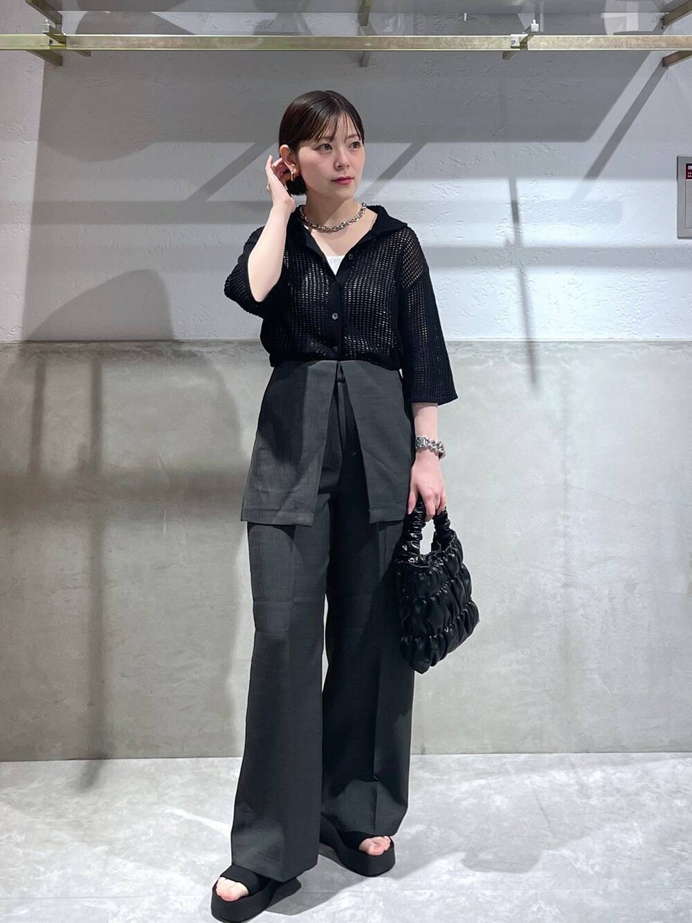 ブラック系のサンダル、ブラック系のショルダーバッグ、ブラック系のニット/セーターを着用したレディースの春コーディネートの2枚目の写真