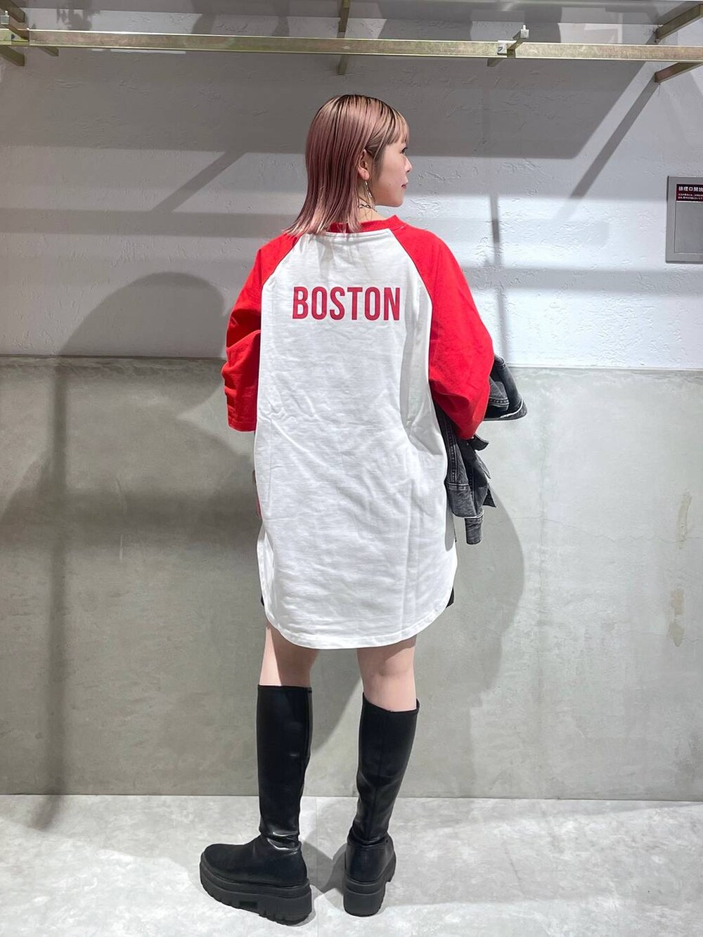 レッド系のTシャツ/カットソー、ブラック系のその他パンツ、ブラック系のブーツを着用したレディースの冬コーディネートの2枚目の写真