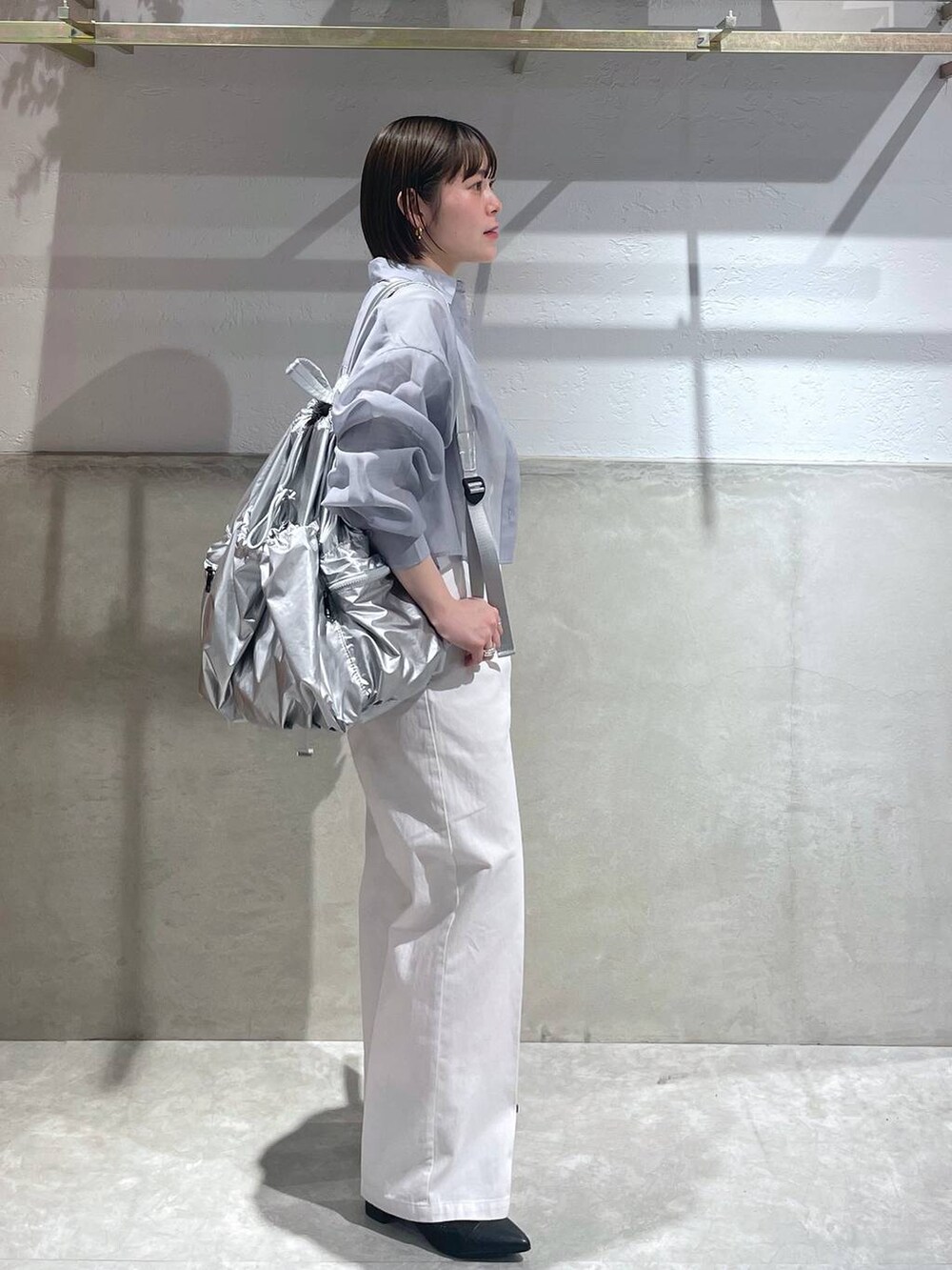 ブラック系のブーツ、ホワイト系のTシャツ/カットソー、ホワイト系のチノパンツを着用したレディースの春コーディネートの2枚目の写真