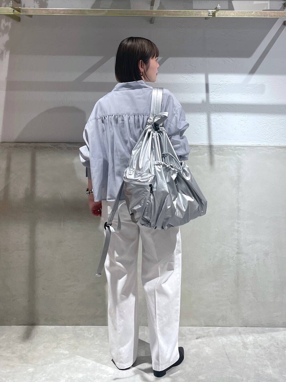 ブラック系のブーツ、ホワイト系のTシャツ/カットソー、ホワイト系のチノパンツを着用したレディースの春コーディネートの4枚目の写真