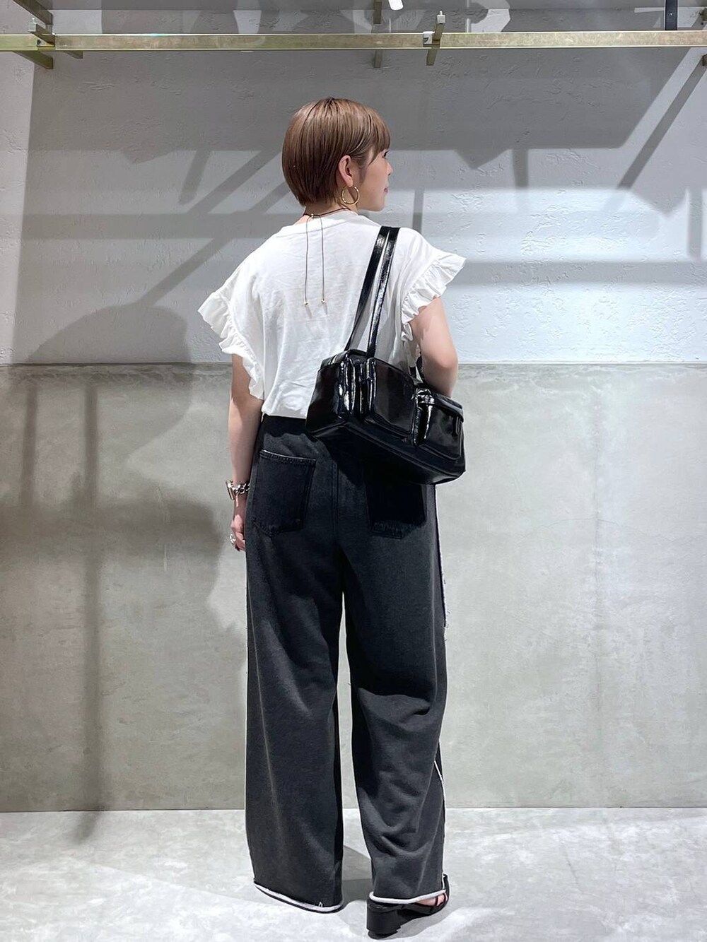 ホワイト系のTシャツ/カットソー、ブラック系のボストンバッグ、ブラック系のデニムパンツを着用したレディースの夏コーディネートの3枚目の写真