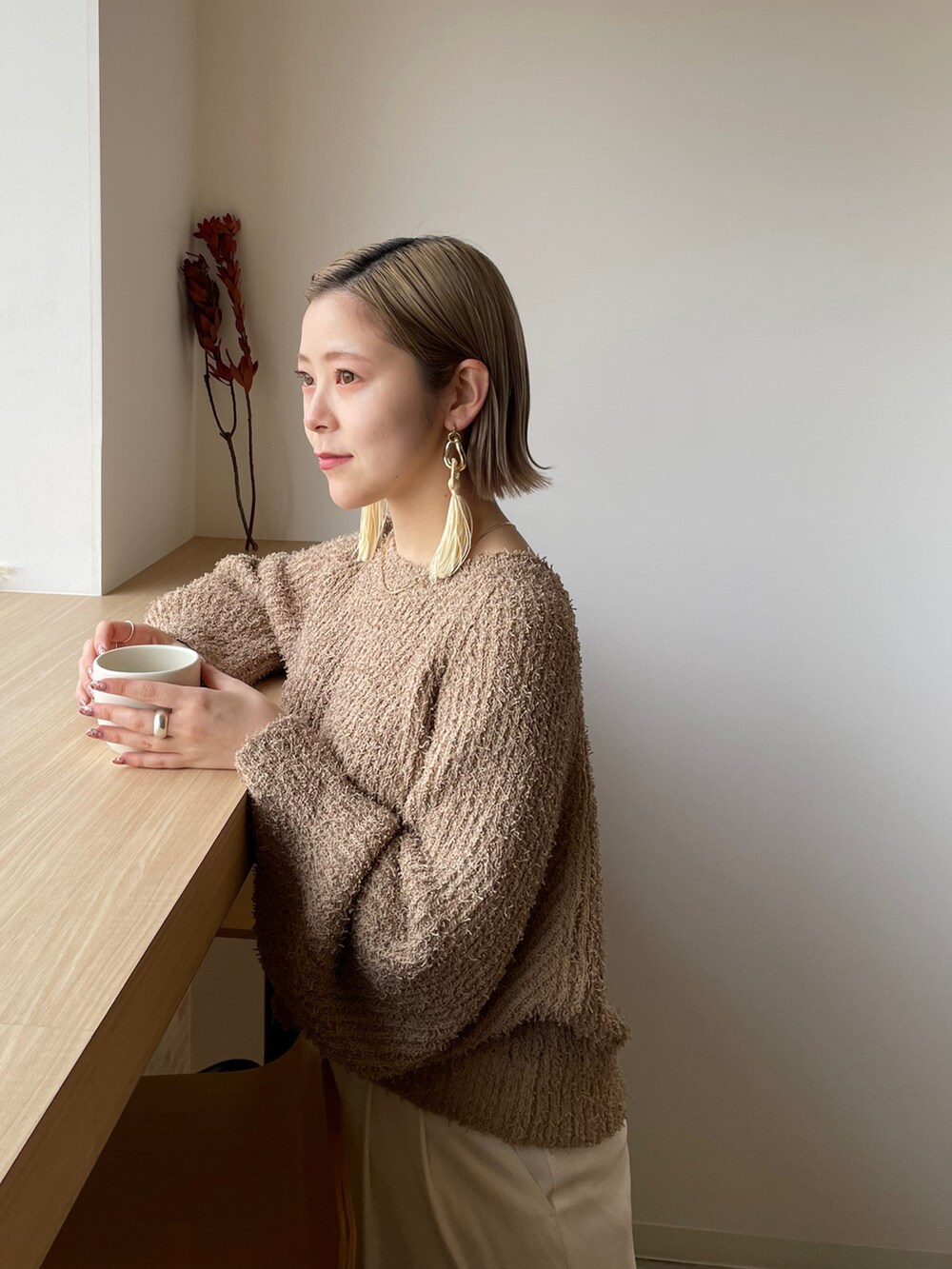 ベージュ系のニット/セーター、ホワイト系のその他パンツ、ブラック系のブーツを着用したレディースの冬コーディネートの3枚目の写真
