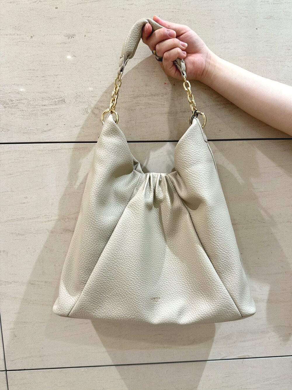 ホワイト系のトートバッグ、ブラウン系のパンプスを着用したレディースの秋コーディネートの7枚目の写真