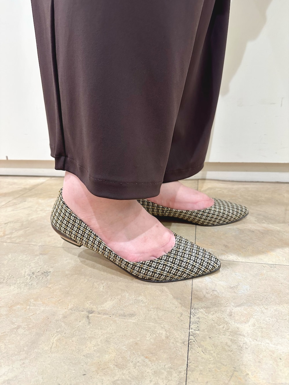 ホワイト系のトートバッグ、ブラウン系のパンプスを着用したレディースの秋コーディネートの4枚目の写真