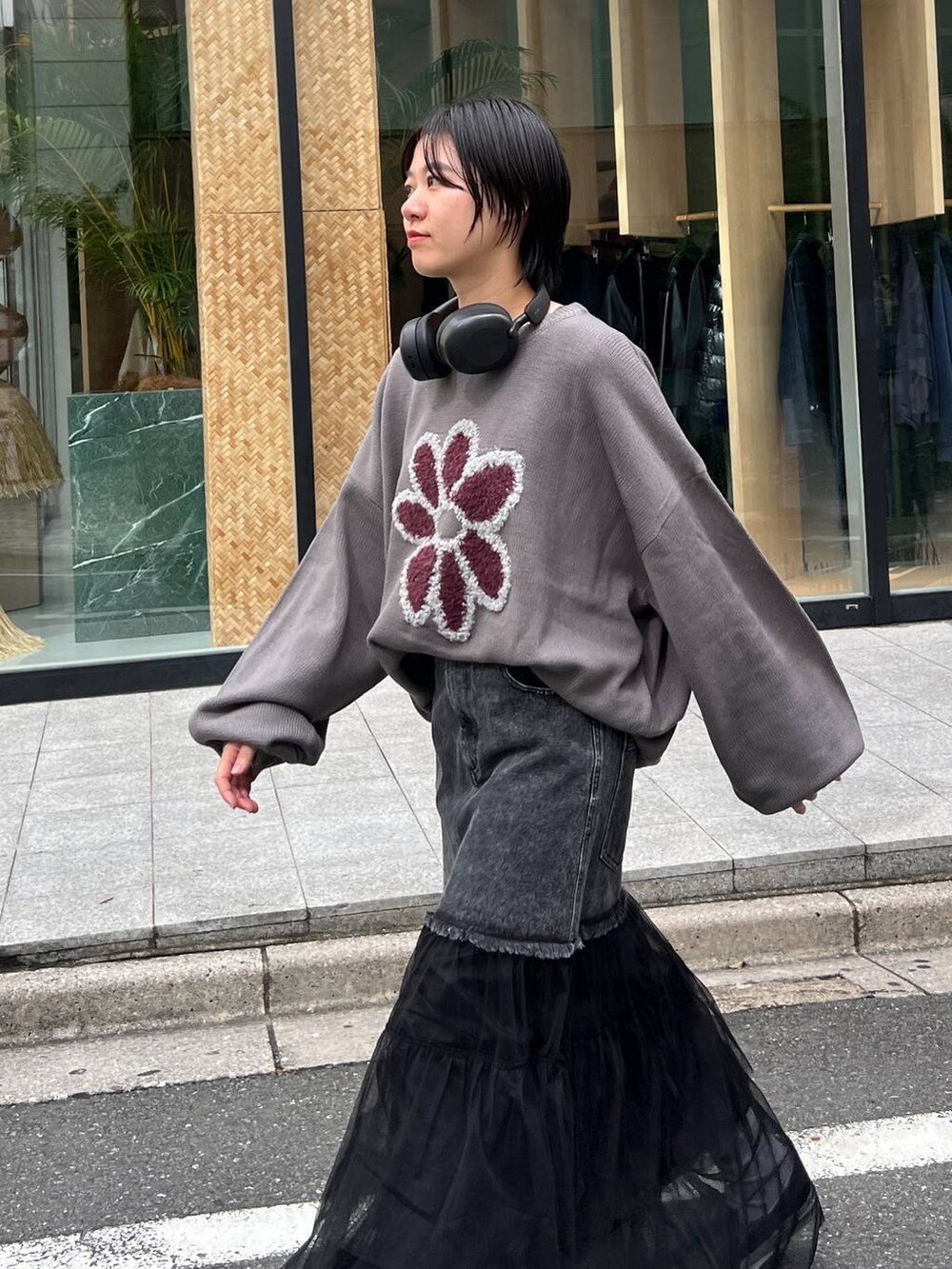 グレー系のニット/セーター、ブルー系のデニムスカートを着用したレディースの秋コーディネートの5枚目の写真