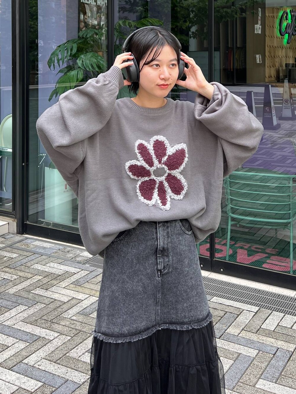 グレー系のニット/セーター、ブルー系のデニムスカートを着用したレディースの秋コーディネートの3枚目の写真