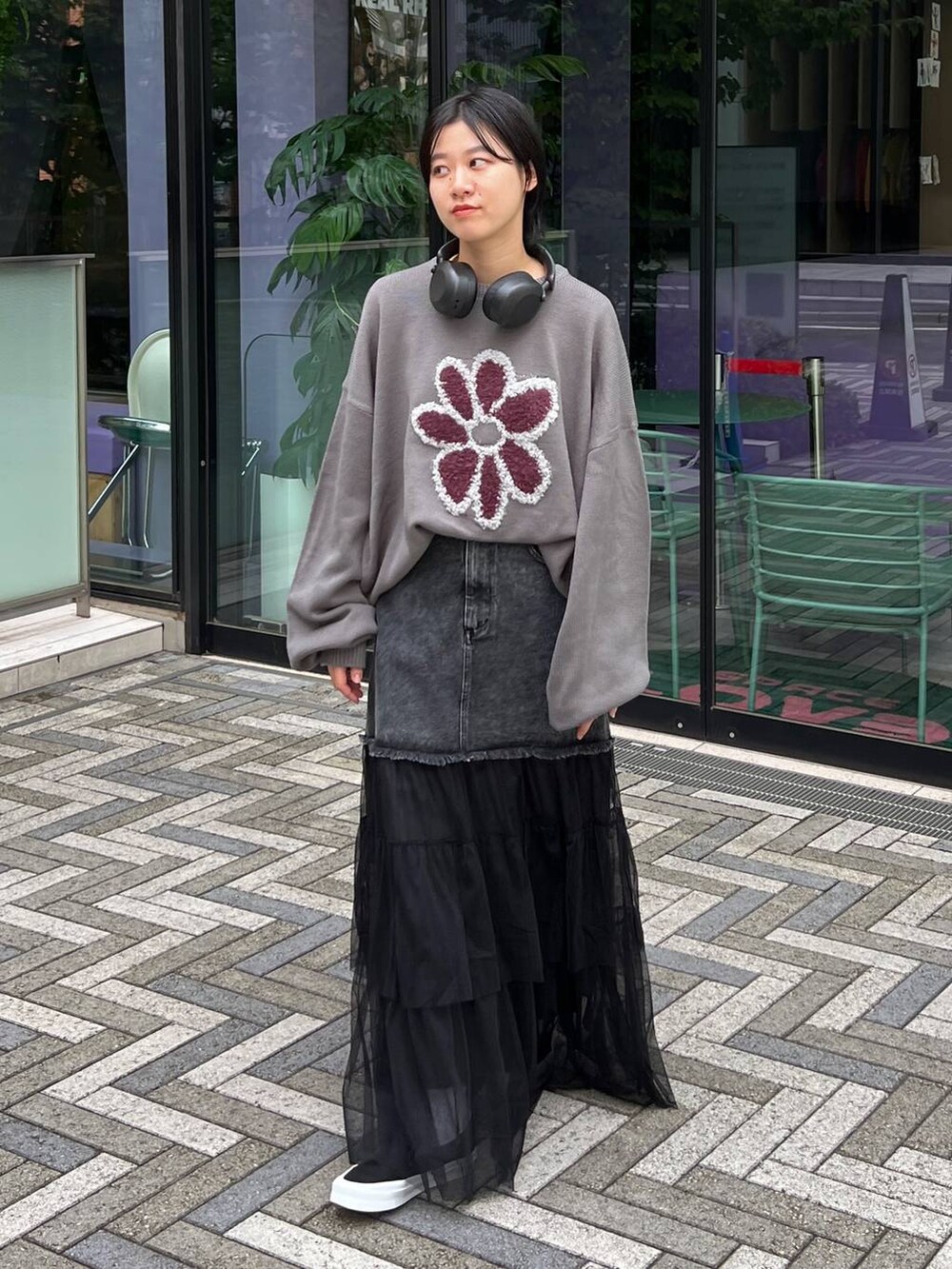 グレー系のニット/セーター、ブルー系のデニムスカートを着用したレディースの秋コーディネートの2枚目の写真