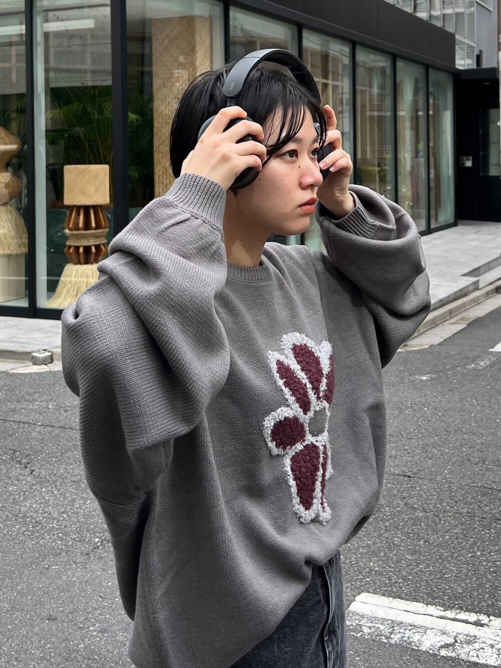 グレー系のニット/セーター、ブルー系のデニムスカートを着用したレディースの秋コーディネートの6枚目の写真