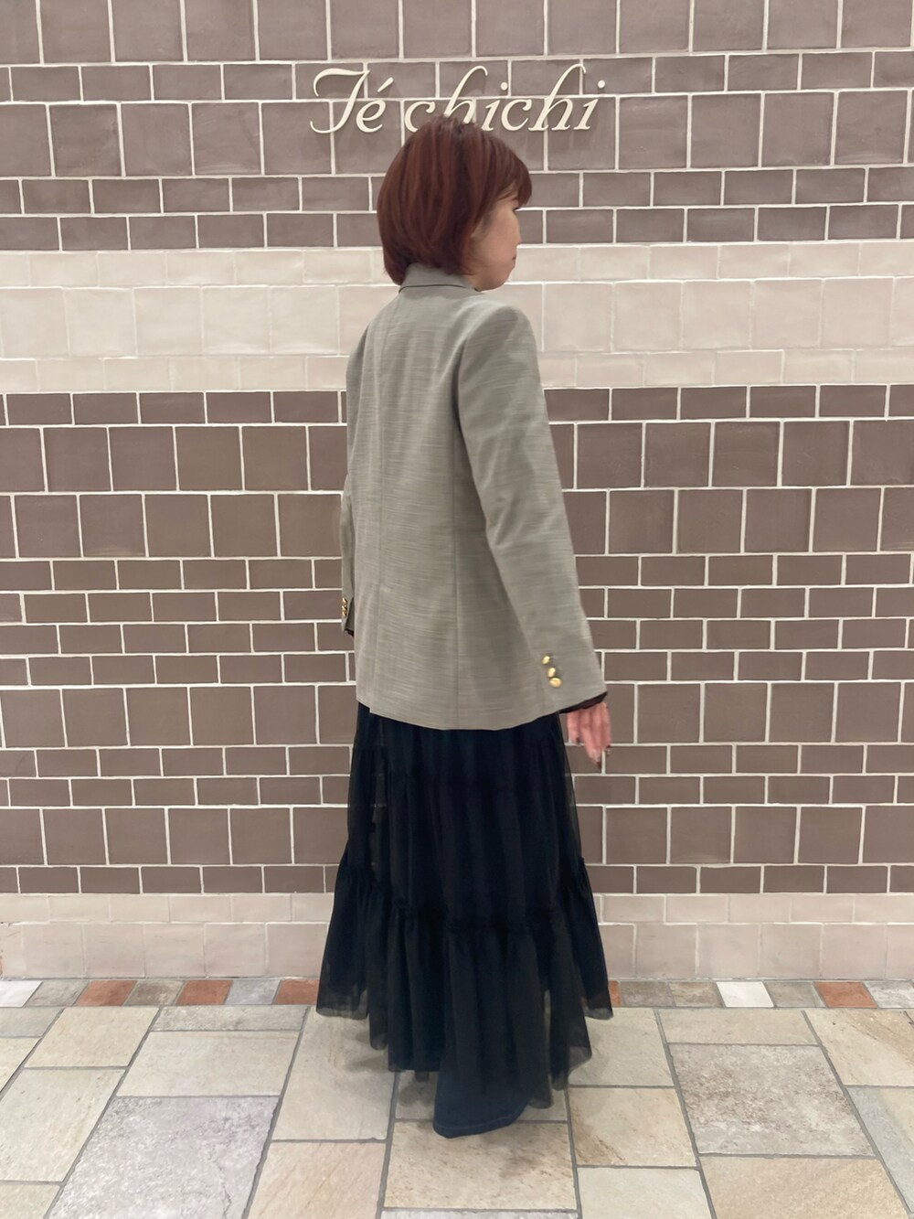 ベージュ系のノーカラージャケット、ブラック系のワンピース/ドレス、ブルー系のデニムパンツを着用したレディースの秋コーディネートの3枚目の写真