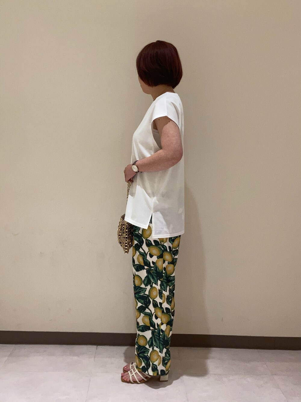 ホワイト系のTシャツ/カットソー、ホワイト系のその他パンツ、ゴールド系のハンドバッグを着用したレディースの夏コーディネートの3枚目の写真