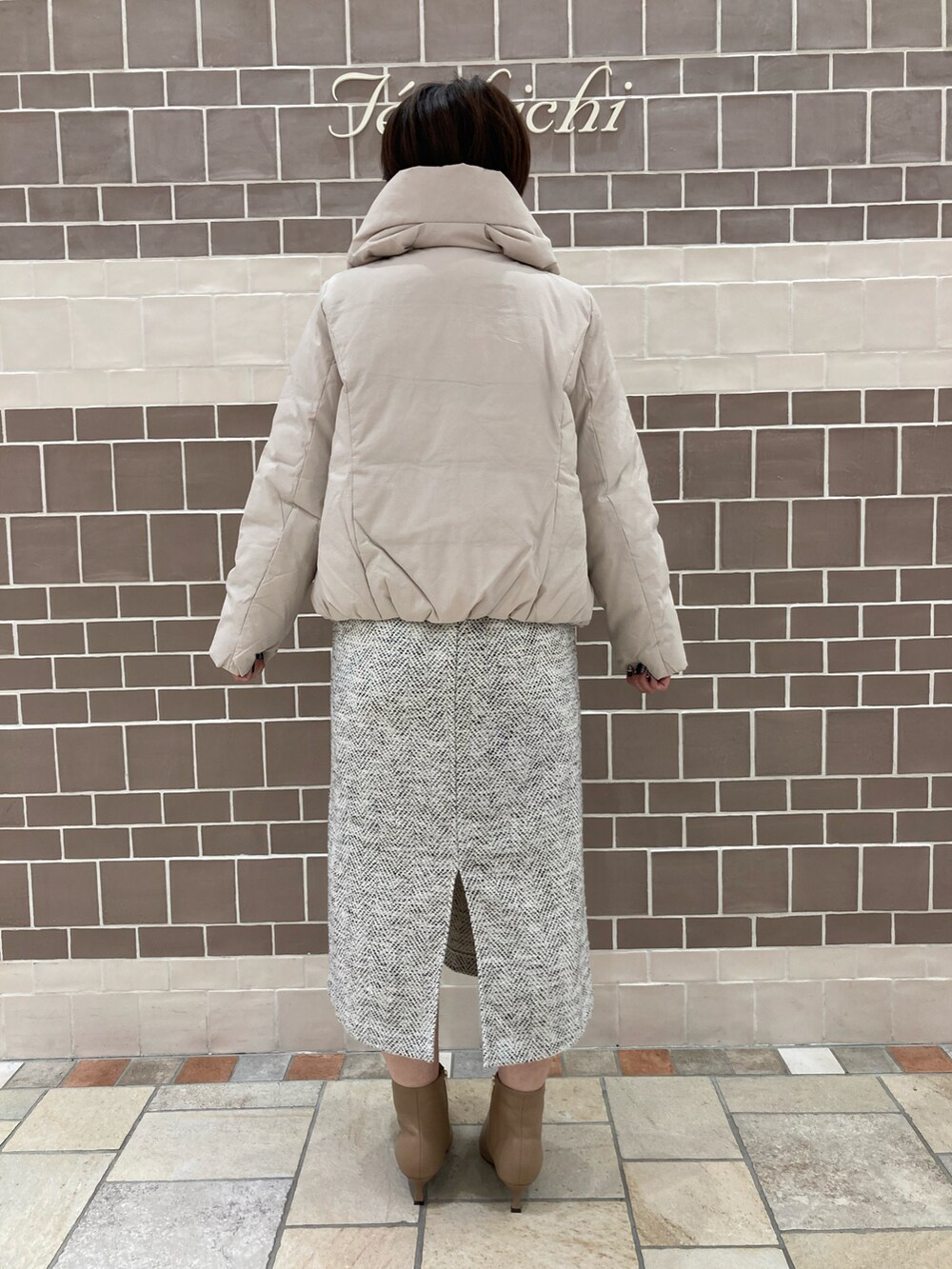 オレンジ系のニット/セーター、グレー系のその他アウターを着用したレディースの冬コーディネートの5枚目の写真