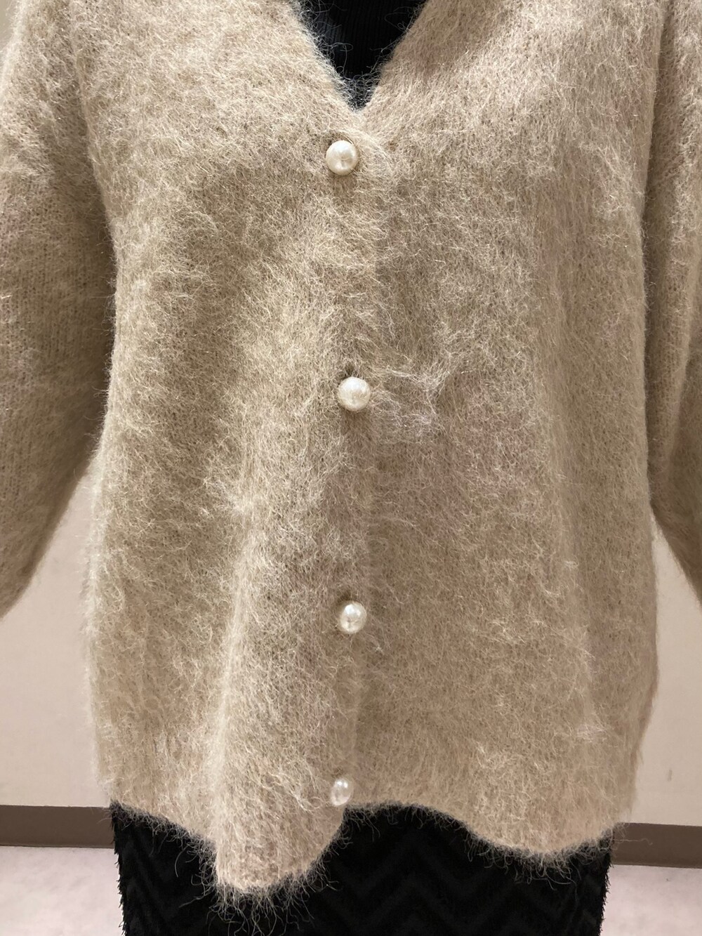 ベージュ系のカーディガン/ボレロ、ブラック系のスカート、ブラック系のブーツを着用したレディースの冬コーディネートの5枚目の写真