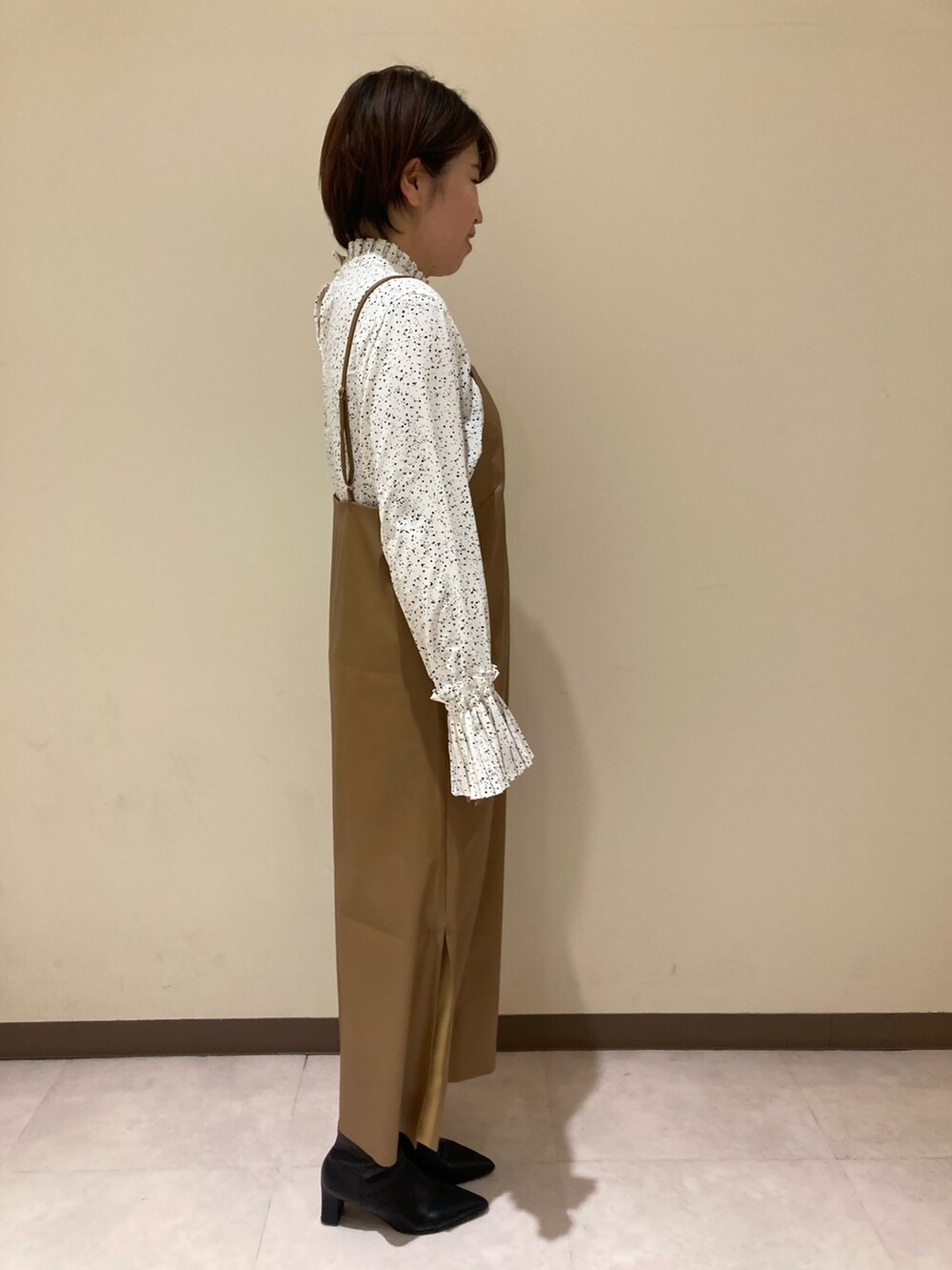 ベージュ系のワンピース、ホワイト系のシャツ/ブラウスを着用したレディースの冬コーディネートの2枚目の写真