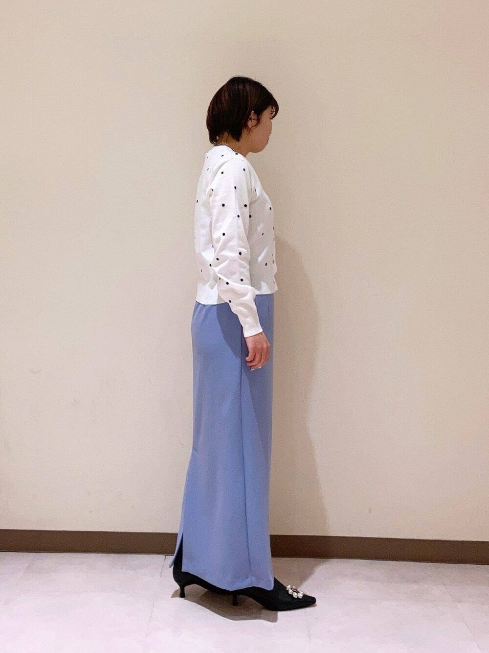 ホワイト系のカーディガン/ボレロ、ブルー系のスカートを着用したレディースの冬コーディネートの3枚目の写真