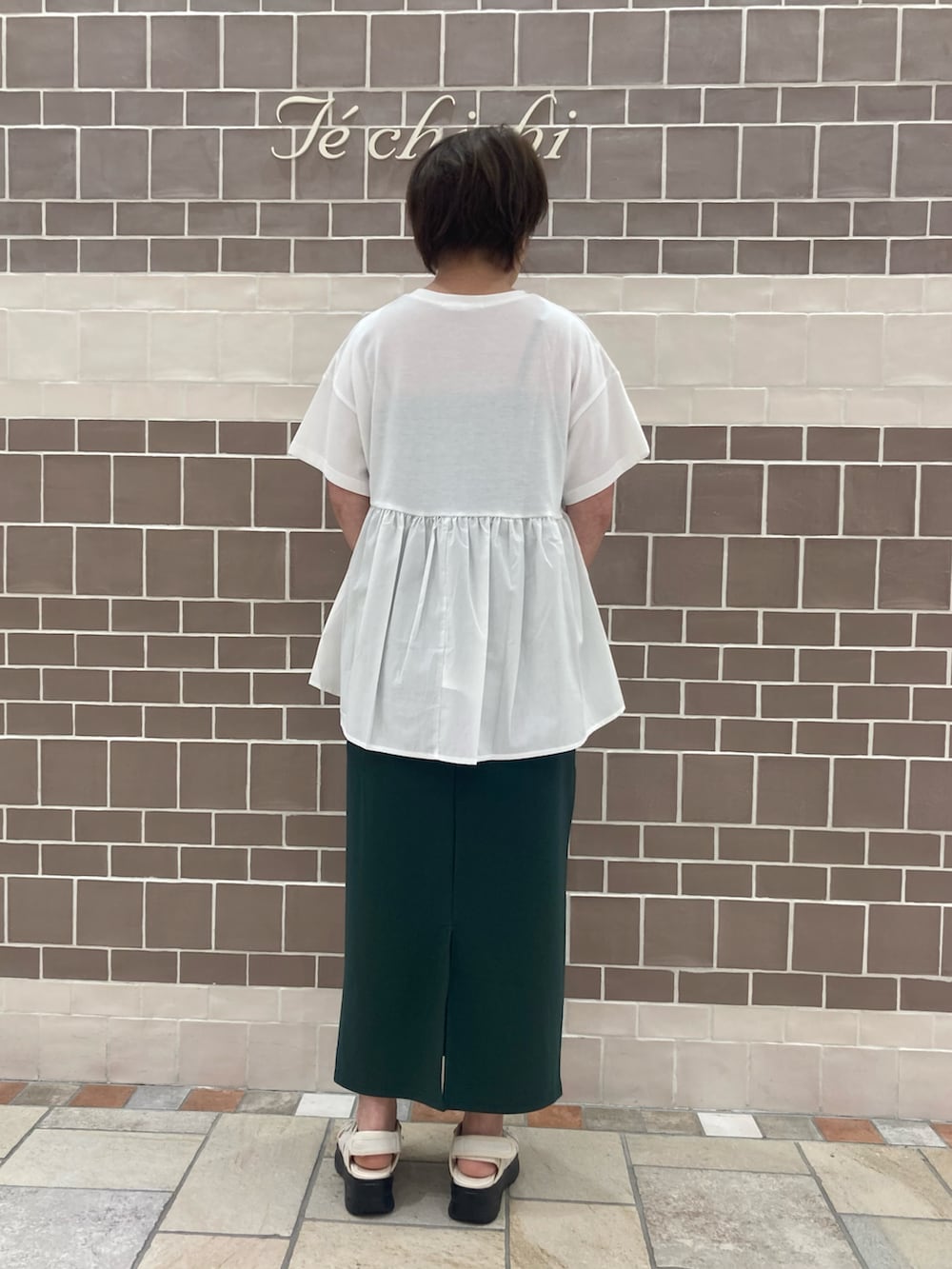 ホワイト系のTシャツ/カットソー、グリーン系のスカート、ホワイト系のハンドバッグを着用したレディースの夏コーディネートの4枚目の写真