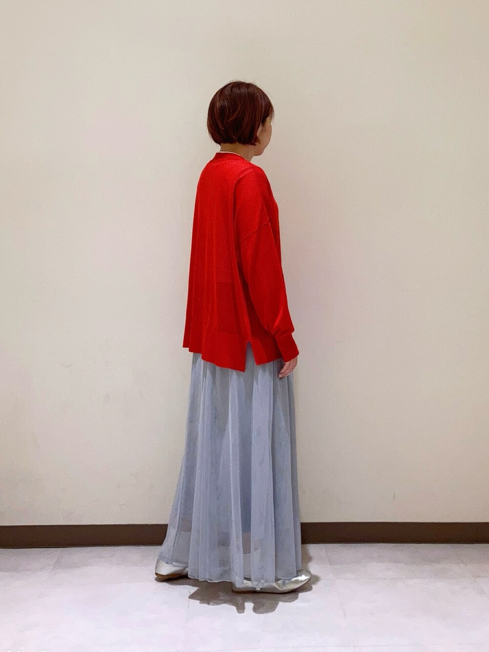 レッド系のカーディガン/ボレロ、グレー系のスカートを着用したレディースの春コーディネートの2枚目の写真