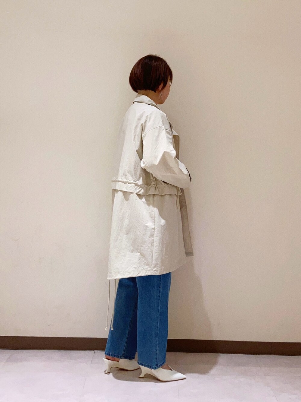 オレンジ系のTシャツ/カットソー、ホワイト系のその他アウター、ブルー系のパンツを着用したレディースの春コーディネートの2枚目の写真
