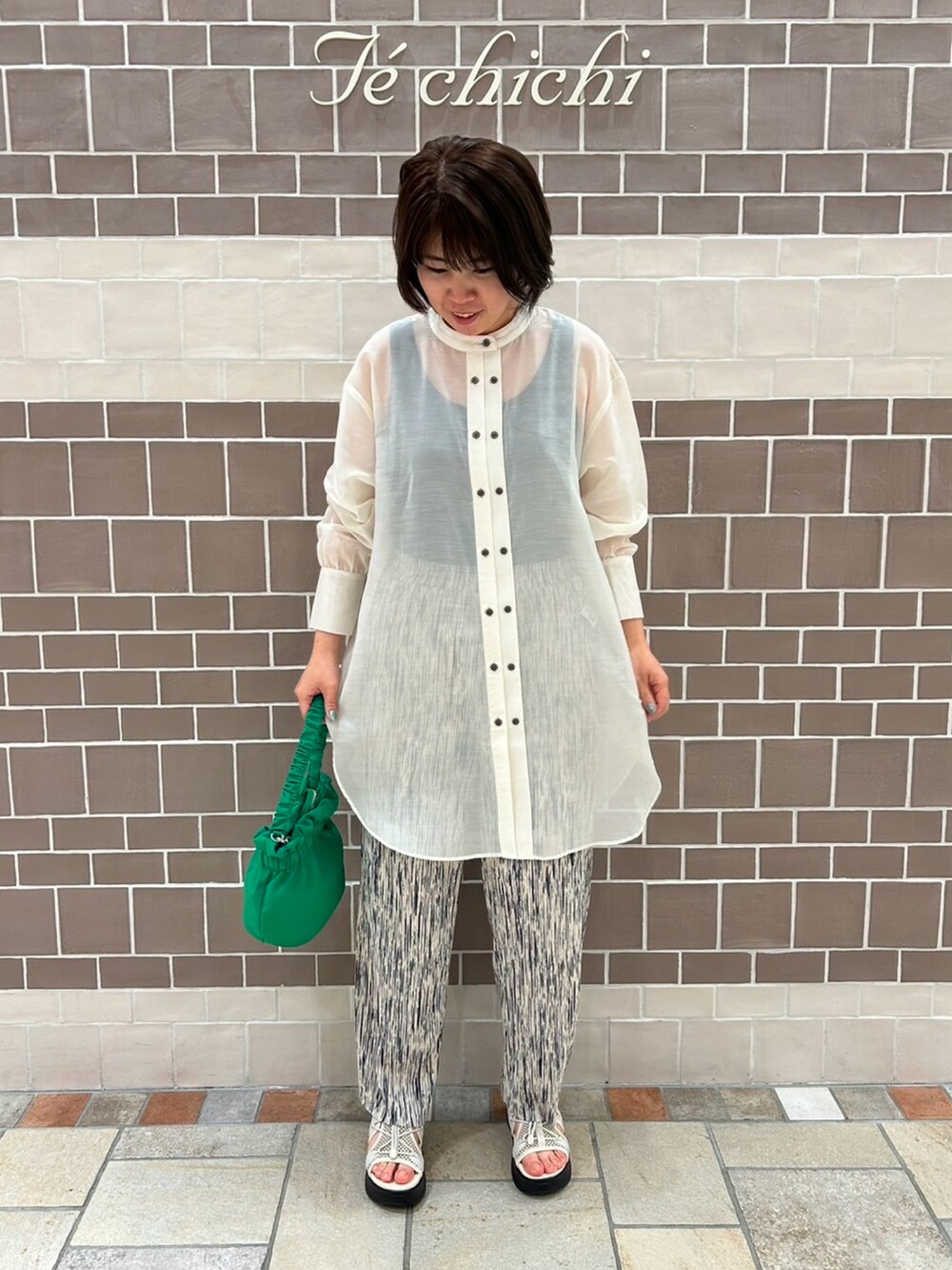 ホワイト系のシャツ/ブラウス、ホワイト系のその他パンツ、グリーン系のハンドバッグを着用したレディースの春コーディネートの2枚目の写真