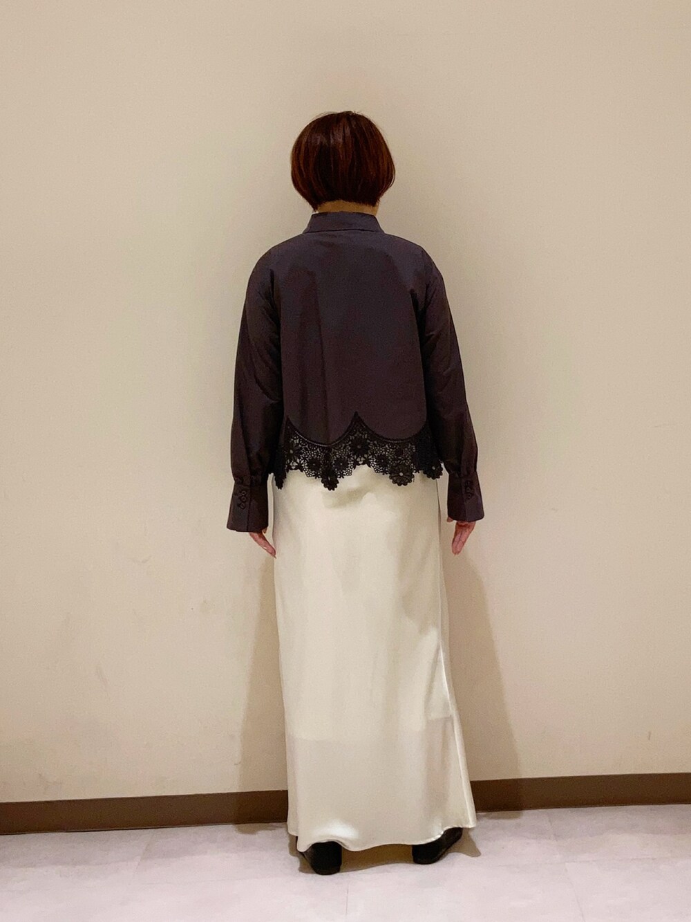 ブラック系のシャツ/ブラウス、ホワイト系のスカートを着用したレディースの春コーディネートの2枚目の写真