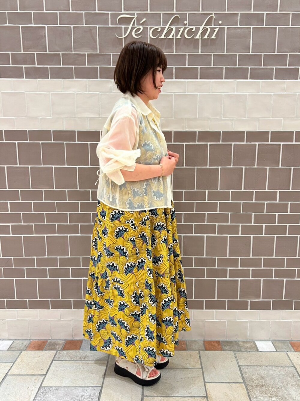 イエロー系のワンピース/ドレス、ホワイト系のシャツ/ブラウスを着用したレディースの春コーディネートの2枚目の写真
