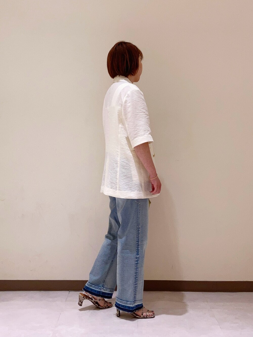 ホワイト系のジャケット/アウターを着用したレディースの春コーディネートの2枚目の写真