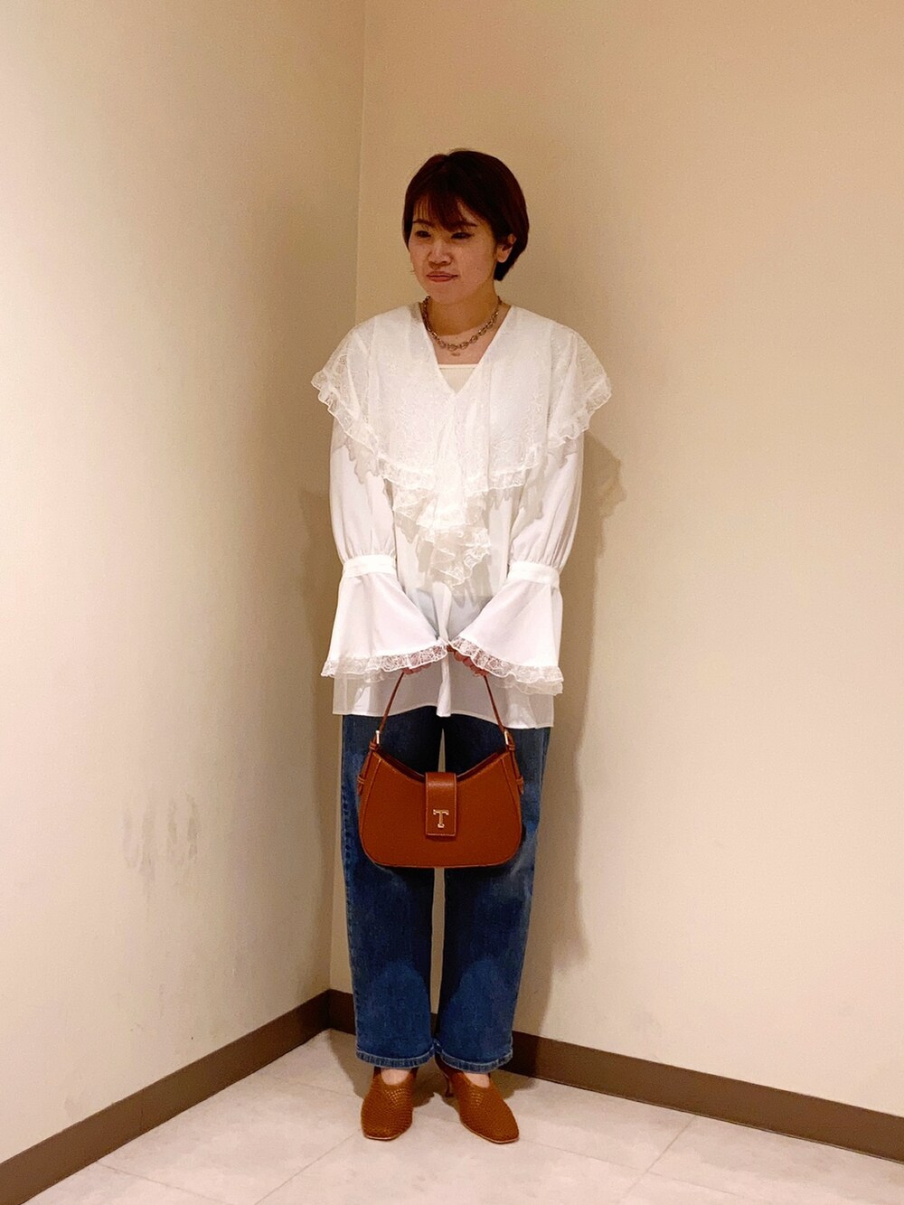 ホワイト系のシャツ/ブラウス、ブラウン系のハンドバッグ、ブラウン系のパンプスを着用したレディースの春コーディネートの2枚目の写真