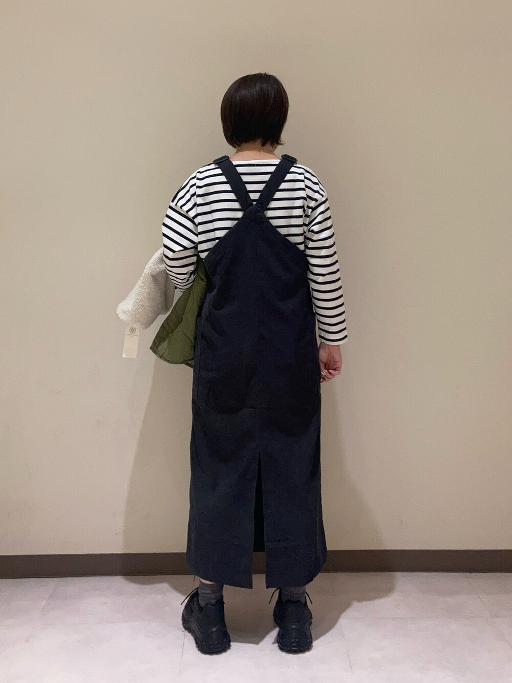 ブラック系のワンピース、グリーン系のその他アウター、ホワイト系のTシャツ/カットソーを着用したレディースの秋コーディネートの5枚目の写真