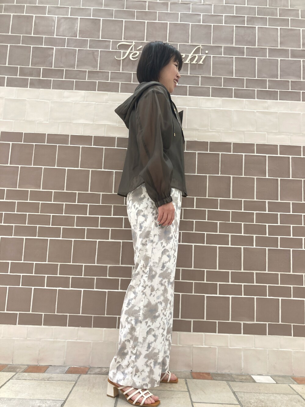 ブラウン系のシャツ/ブラウス、ベージュ系のその他パンツ、ホワイト系のサンダルを着用したレディースの春コーディネートの3枚目の写真