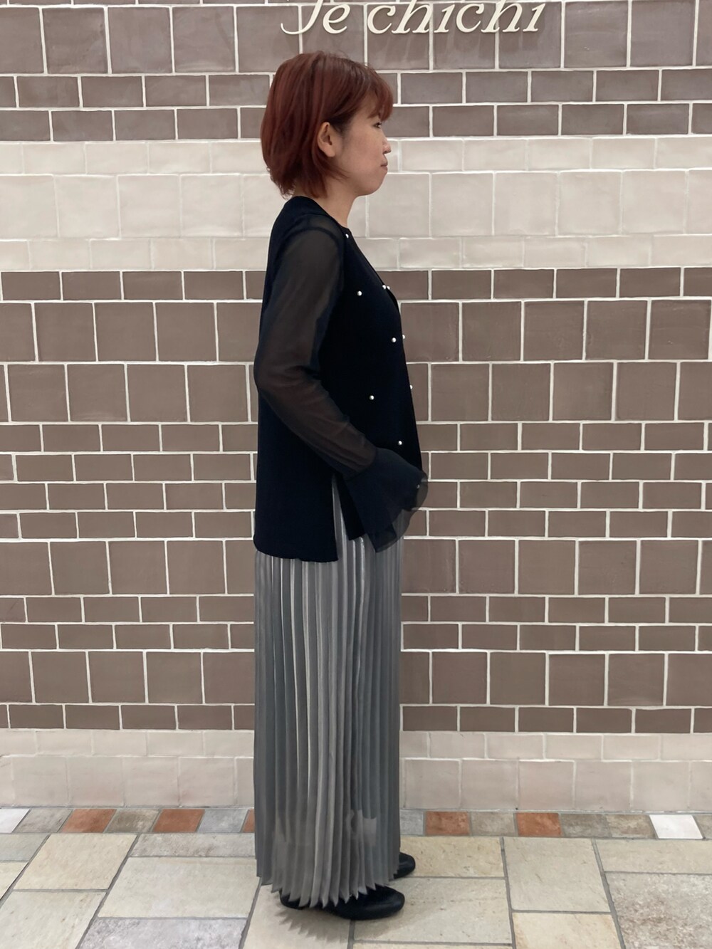 ブラック系のTシャツ/カットソー、グレー系のスカートを着用したレディースの秋コーディネートの2枚目の写真