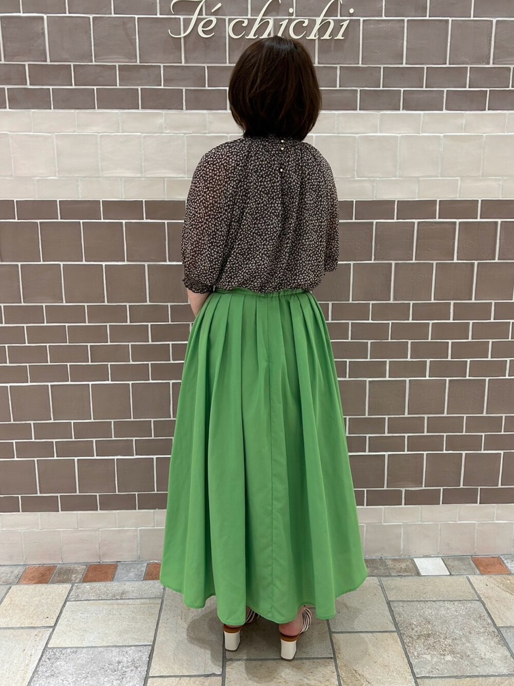 グリーン系のスカート、ホワイト系のサンダル、グレー系のシャツ/ブラウスを着用したレディースの春コーディネートの3枚目の写真