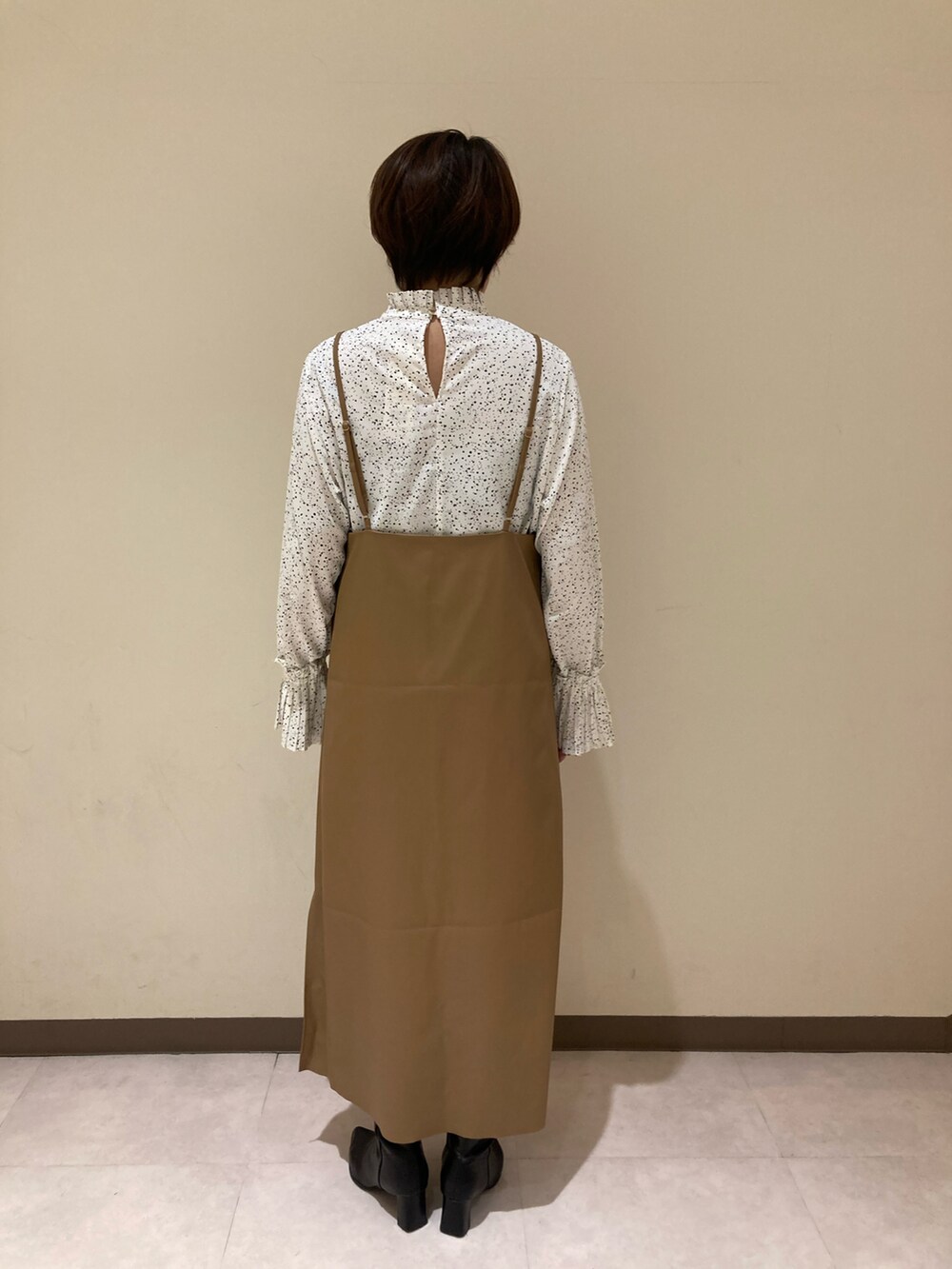 ベージュ系のワンピース、ホワイト系のシャツ/ブラウスを着用したレディースの冬コーディネートの3枚目の写真