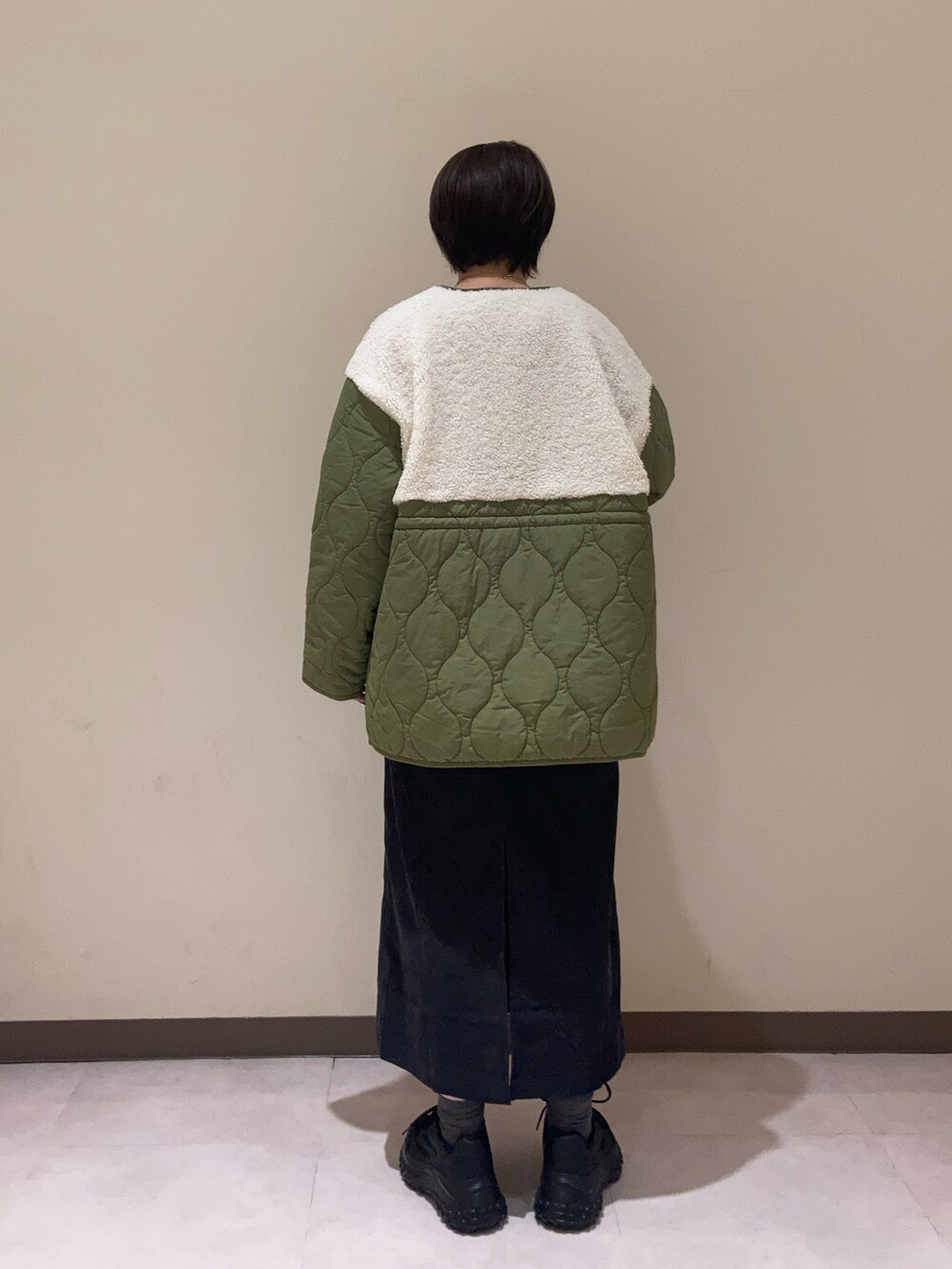 ブラック系のワンピース、グリーン系のその他アウター、ホワイト系のTシャツ/カットソーを着用したレディースの秋コーディネートの3枚目の写真