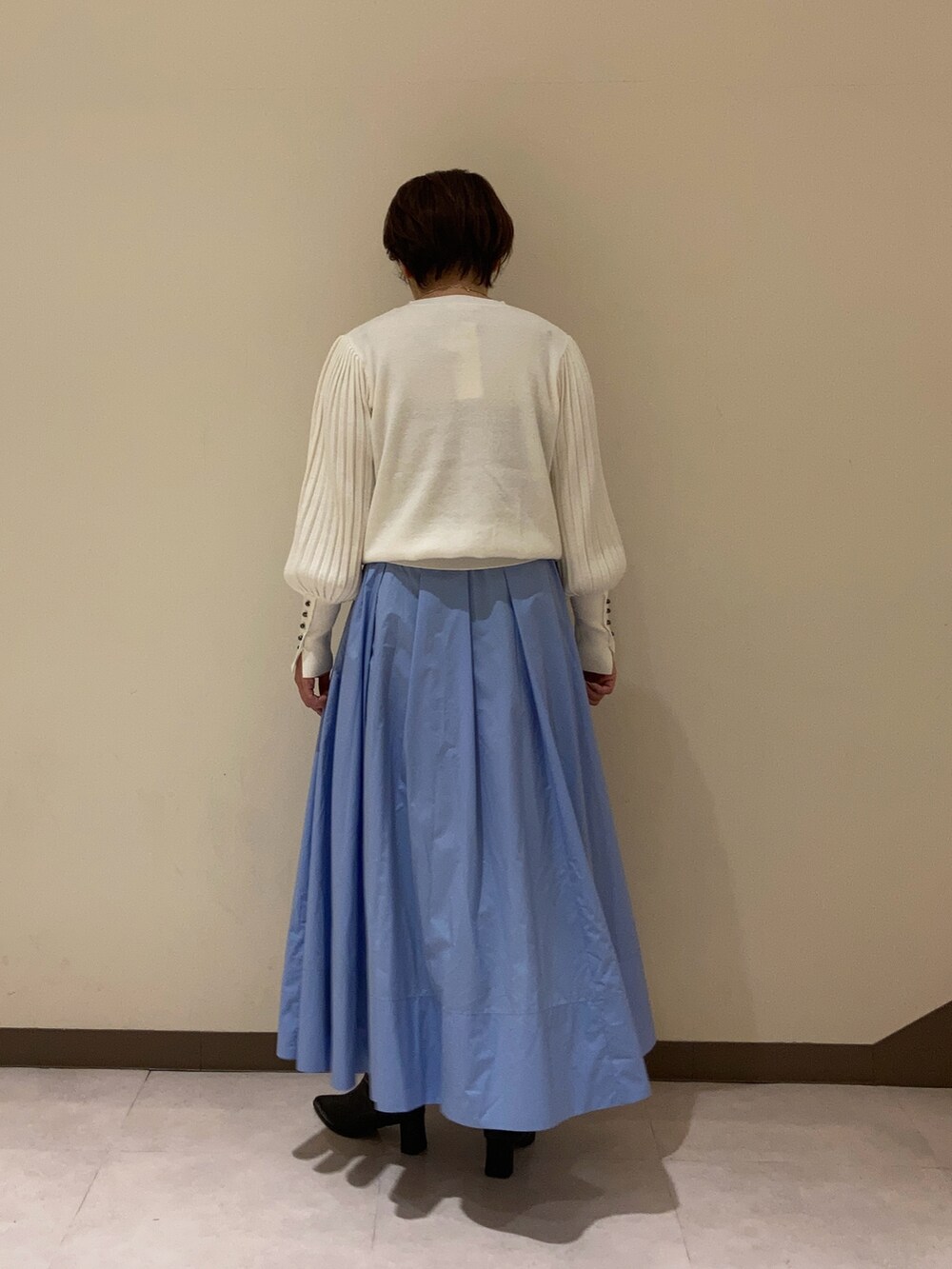 ホワイト系のニット/セーター、ブルー系のスカートを着用したレディースの冬コーディネートの4枚目の写真