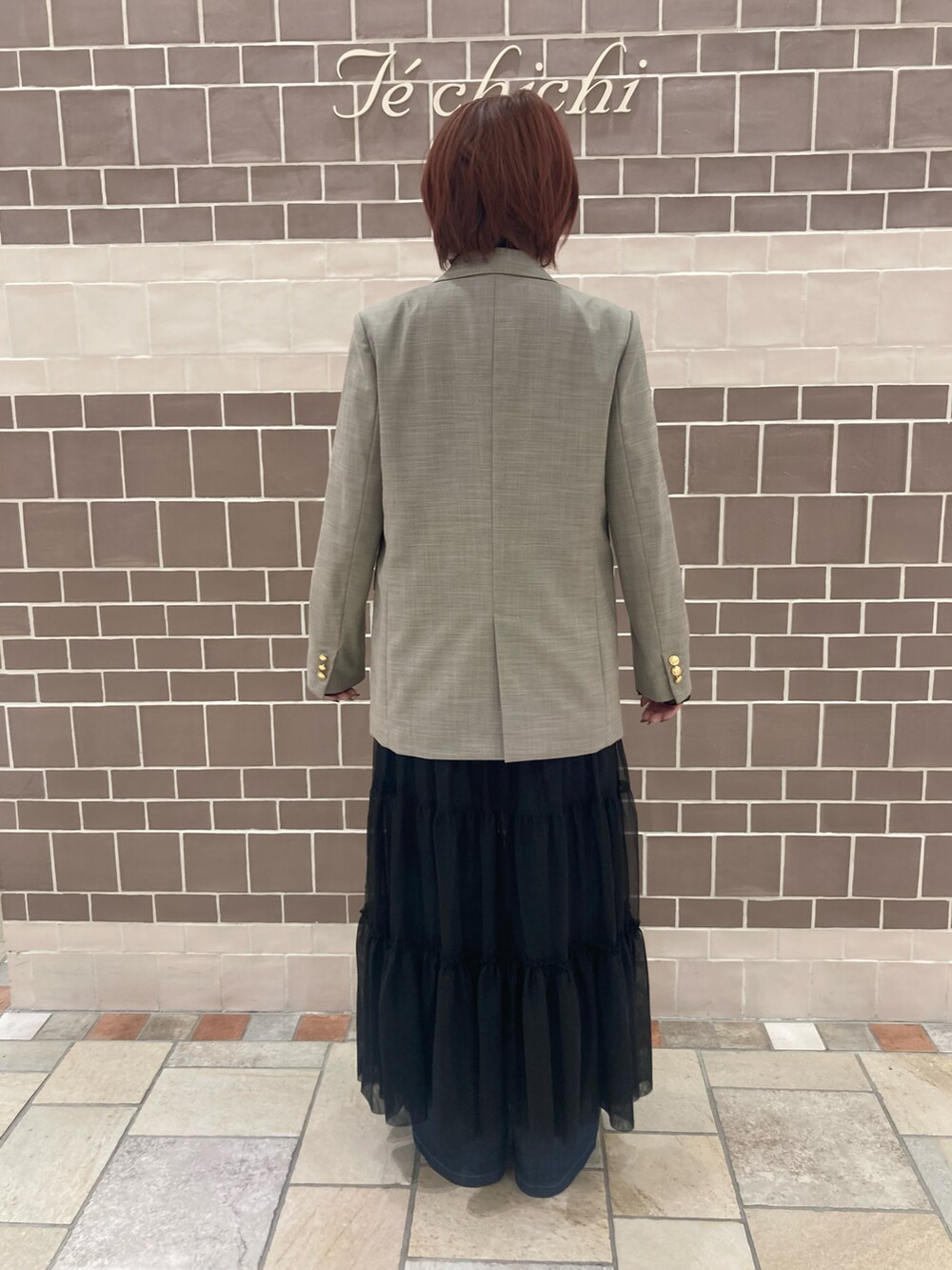 ベージュ系のノーカラージャケット、ブラック系のワンピース/ドレス、ブルー系のデニムパンツを着用したレディースの秋コーディネートの5枚目の写真