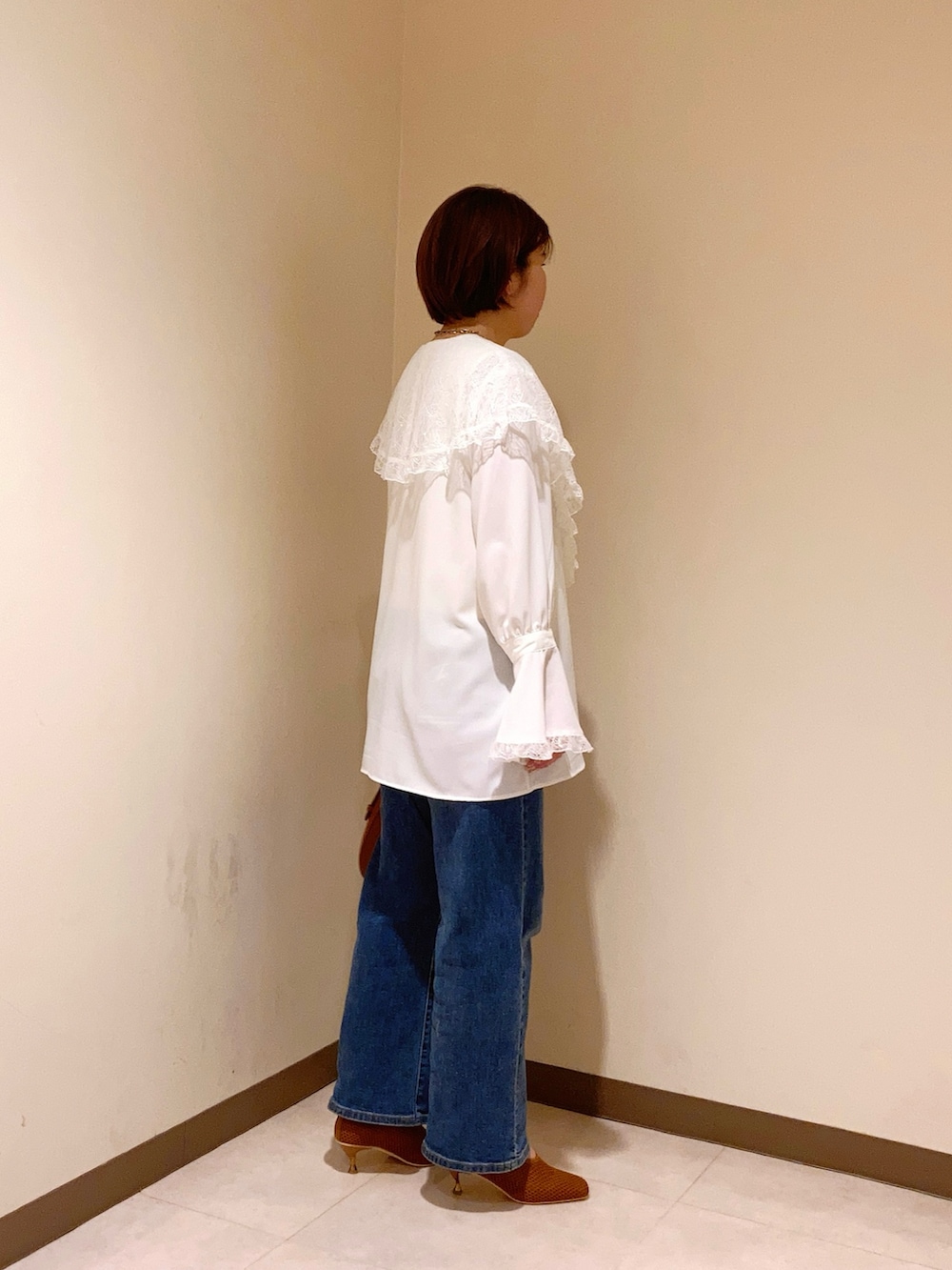 ホワイト系のシャツ/ブラウス、ブラウン系のハンドバッグ、ブラウン系のパンプスを着用したレディースの春コーディネートの4枚目の写真