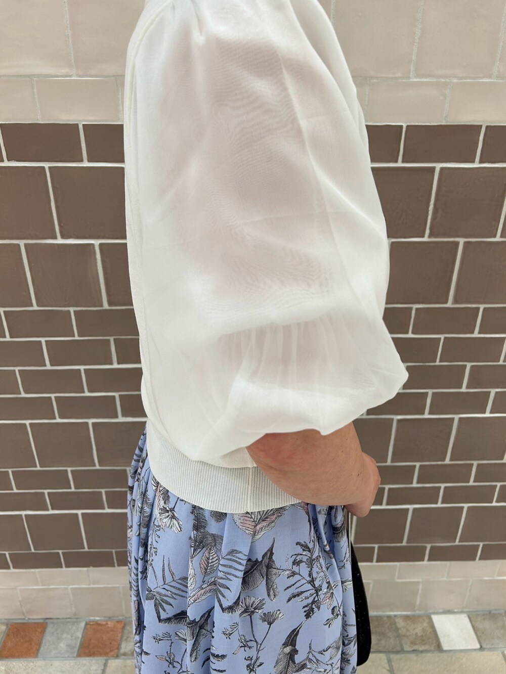 ホワイト系のニット/セーター、ブルー系のスカート、ホワイト系のサンダルを着用したレディースの春コーディネートの4枚目の写真