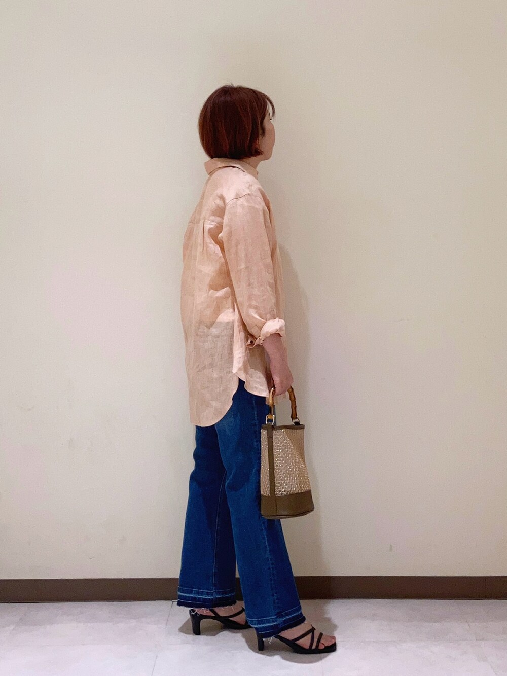 ピンク系のシャツ/ブラウス、ブラウン系のハンドバッグ、ブラウン系のサンダルを着用したレディースの春コーディネートの2枚目の写真