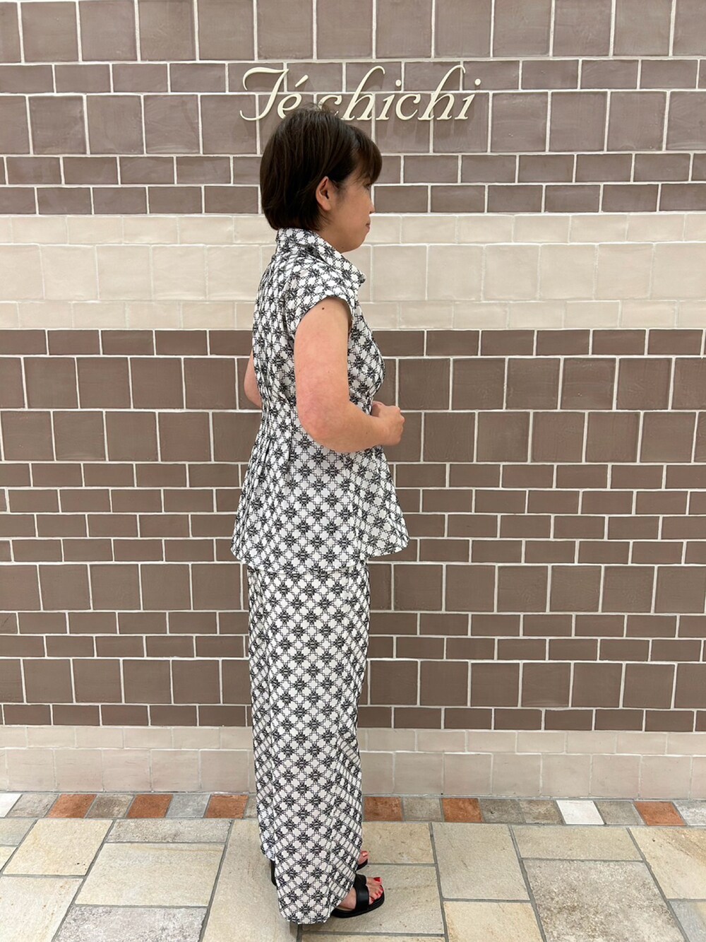 ホワイト系のシャツ/ブラウス、ホワイト系のパンツ、ブラック系のサンダルを着用したレディースの夏コーディネートの3枚目の写真