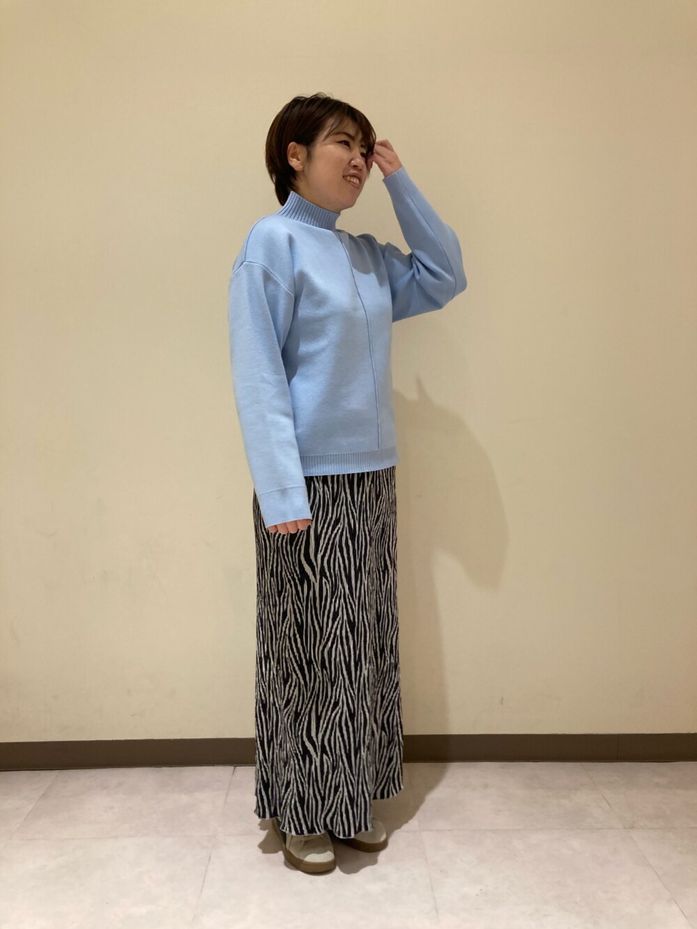 ブルー系のニット/セーター、ブラック系のスカートを着用したレディースの冬コーディネートの2枚目の写真