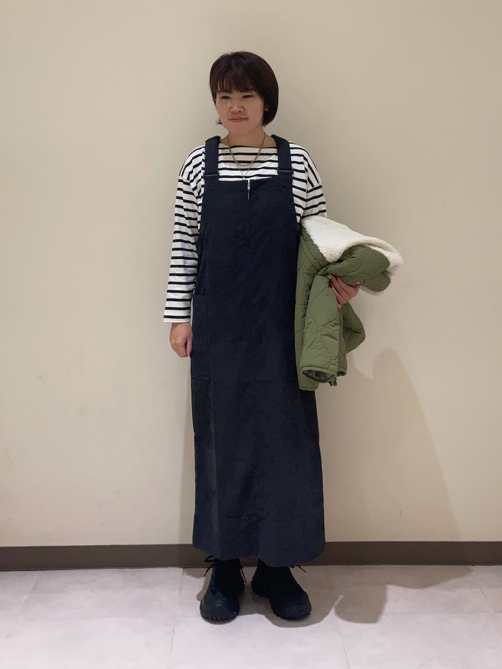 ブラック系のワンピース、グリーン系のその他アウター、ホワイト系のTシャツ/カットソーを着用したレディースの秋コーディネートの4枚目の写真