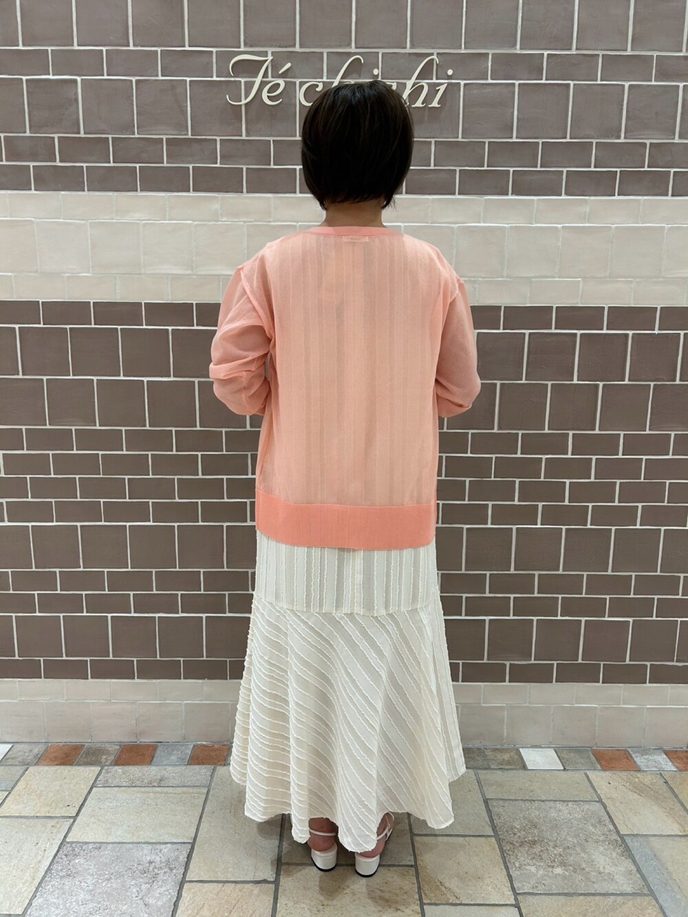 ホワイト系のワンピース、ピンク系のカーディガン/ボレロ、ホワイト系のサンダルを着用したレディースの夏コーディネートの4枚目の写真