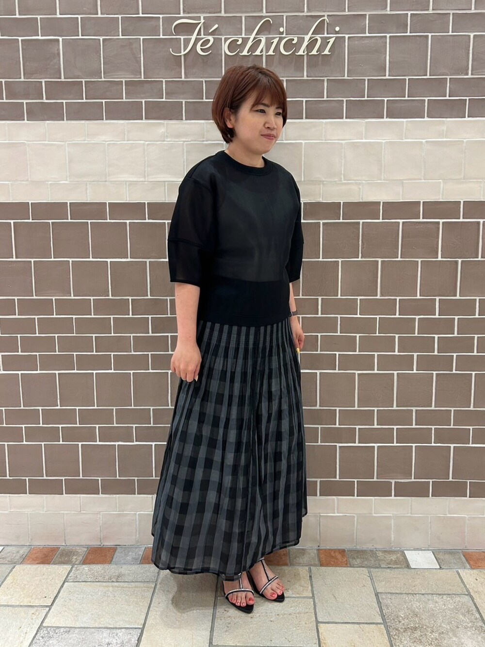 ブラック系のシャツ/ブラウス、ブラック系のスカート、シルバー系のハンドバッグを着用したレディースの春コーディネートの5枚目の写真