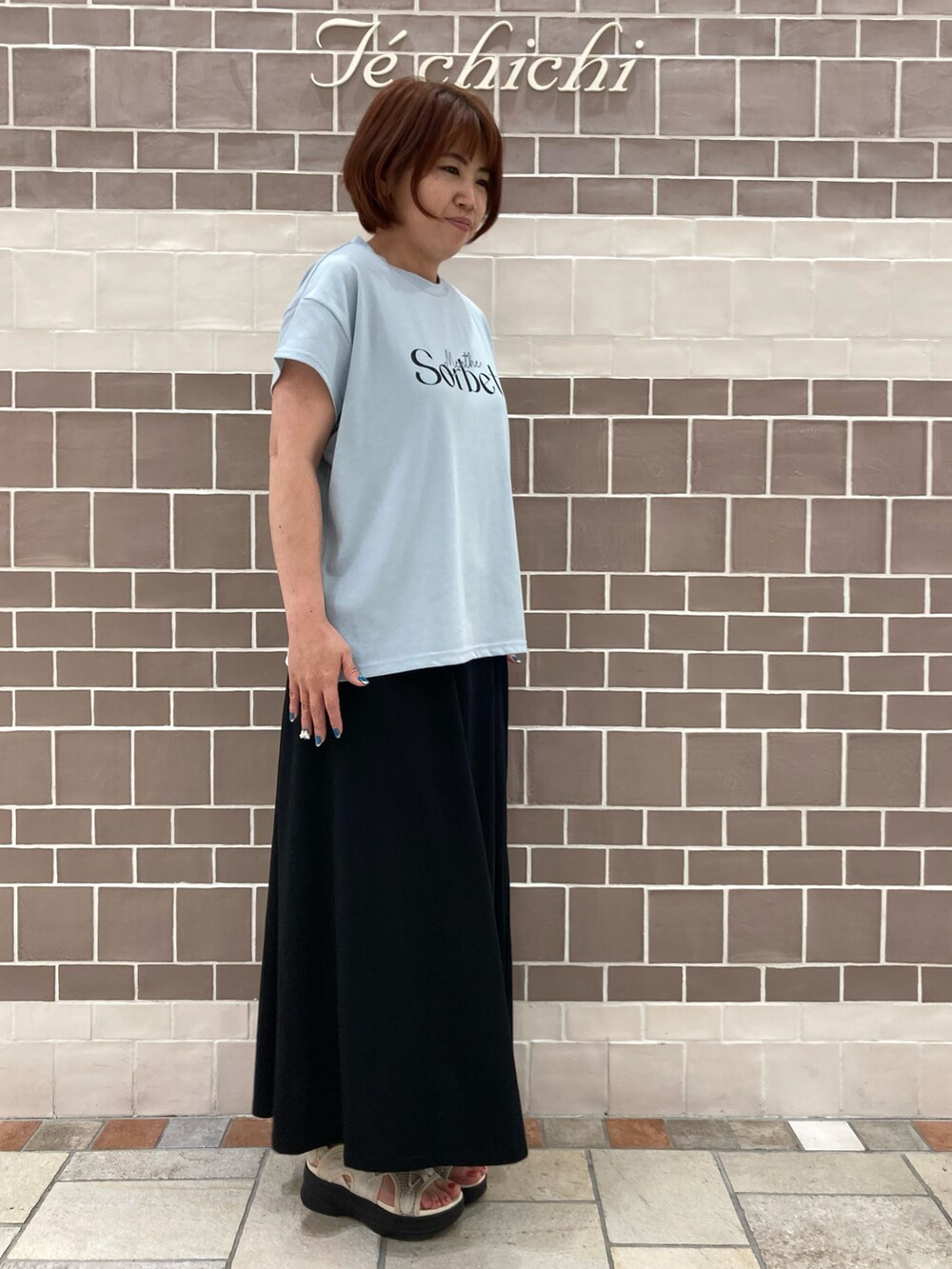 ブルー系のTシャツ/カットソー、ブラック系のスカートを着用したレディースの夏コーディネートの3枚目の写真