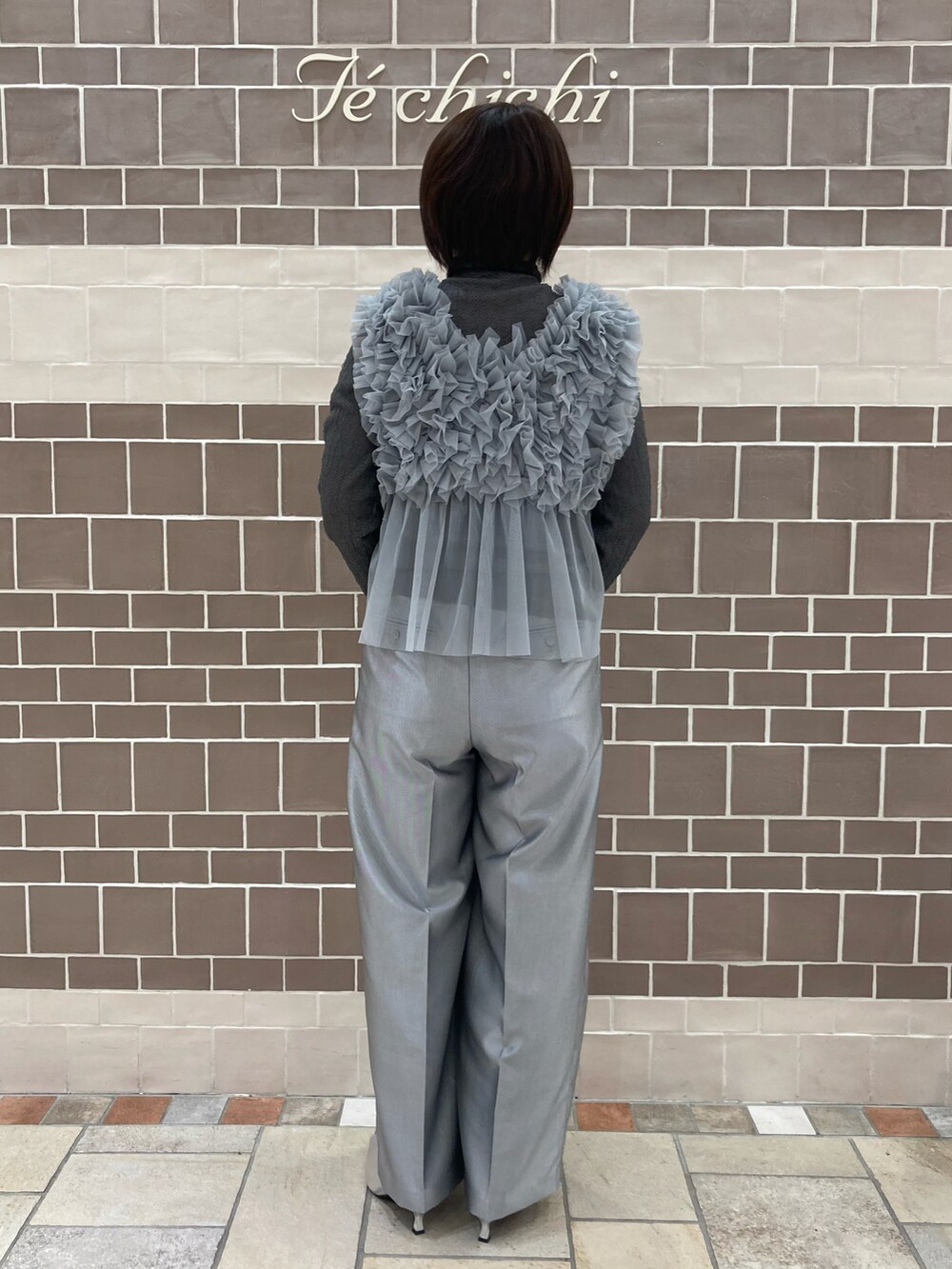 グレー系のニット/セーター、シルバー系のハンドバッグを着用したレディースの秋コーディネートの4枚目の写真