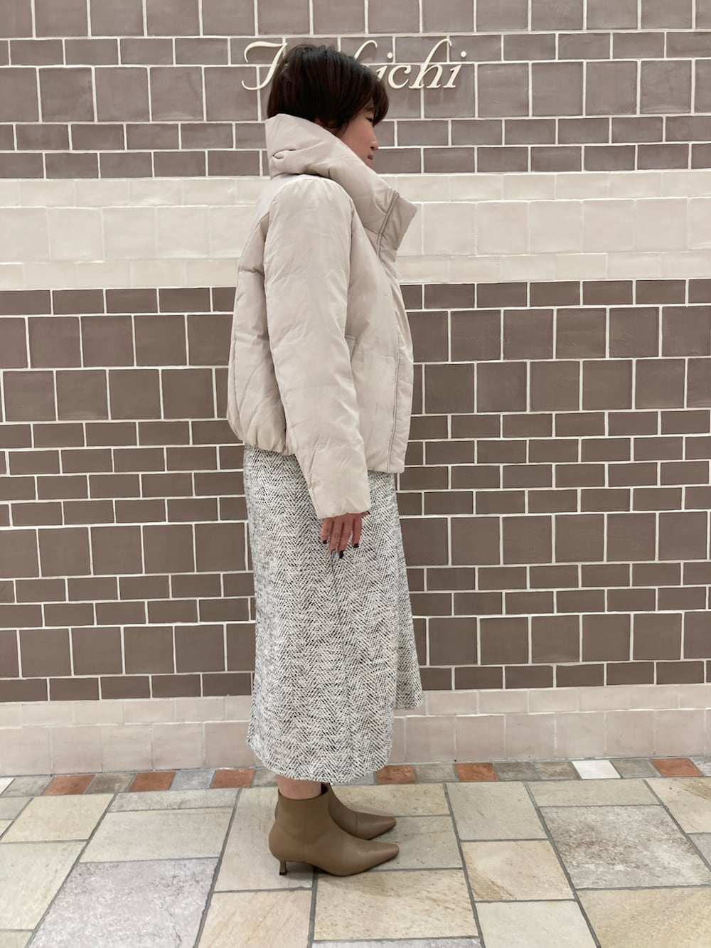 オレンジ系のニット/セーター、グレー系のその他アウターを着用したレディースの冬コーディネートの4枚目の写真