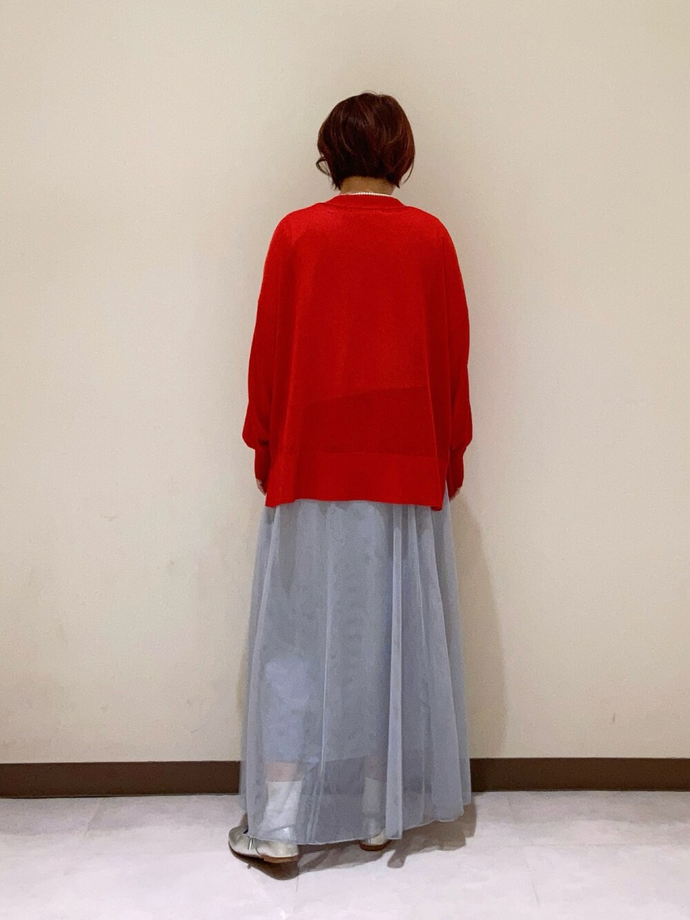 レッド系のカーディガン/ボレロ、グレー系のスカートを着用したレディースの春コーディネートの3枚目の写真