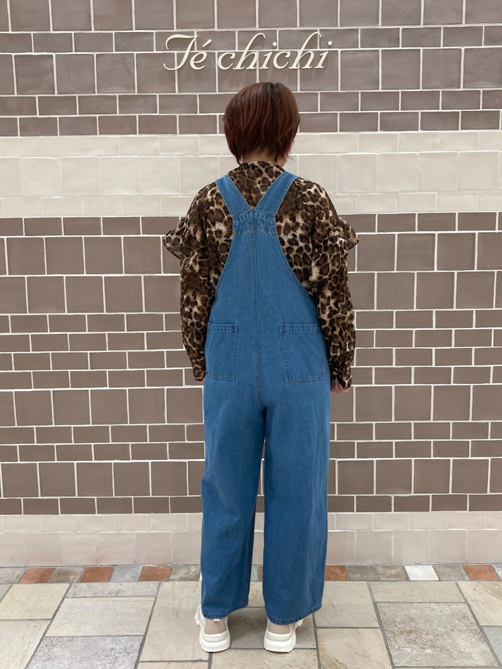 ブルー系のサロペット/オーバーオール、ブラウン系のシャツ/ブラウス、ブラウン系のスニーカーを着用したレディースの夏コーディネートの4枚目の写真