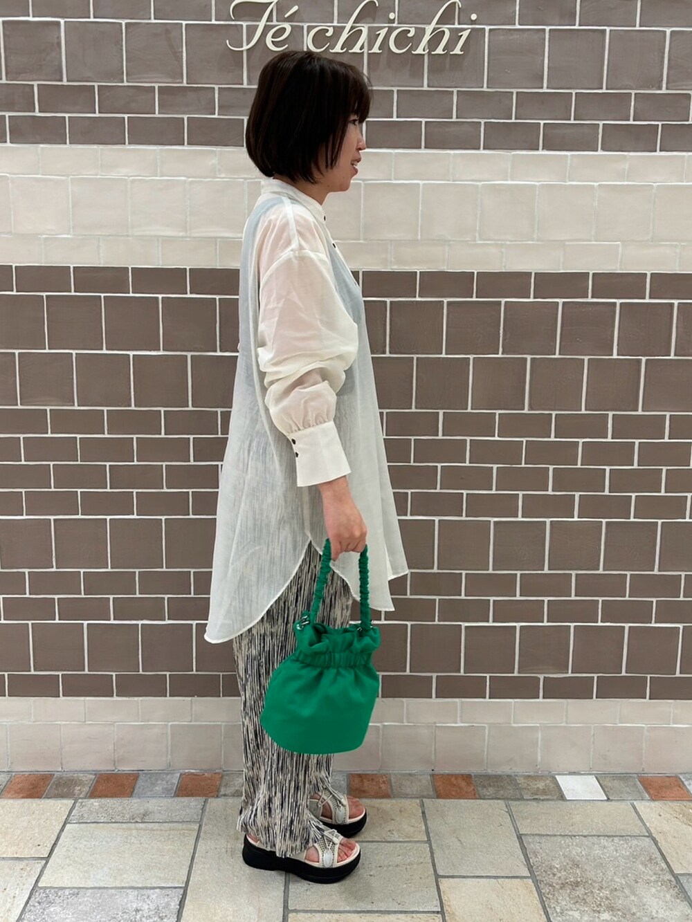 ホワイト系のシャツ/ブラウス、ホワイト系のその他パンツ、グリーン系のハンドバッグを着用したレディースの春コーディネートの3枚目の写真